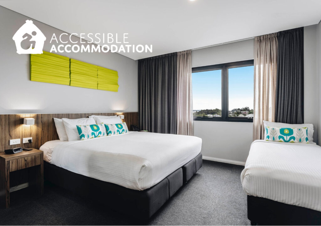 Accessible accommodation room at ibis Styles The Entrance featuring a king bed, single bed, spacious layout, wheelchair-friendly design, modern furnishings and large window with natural light.
